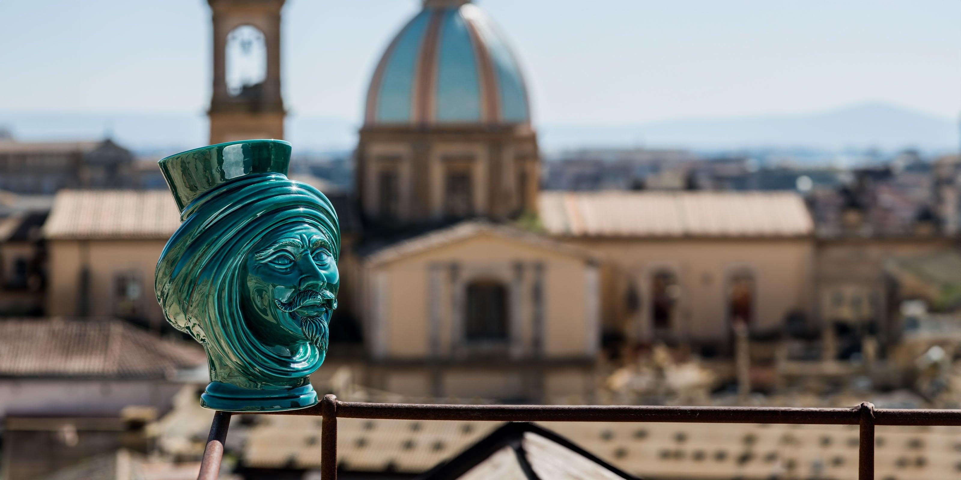 Ceramiche Caltagirone fatti a mano, brocca verde con volto maschile, sfondo città con cupola e campanile