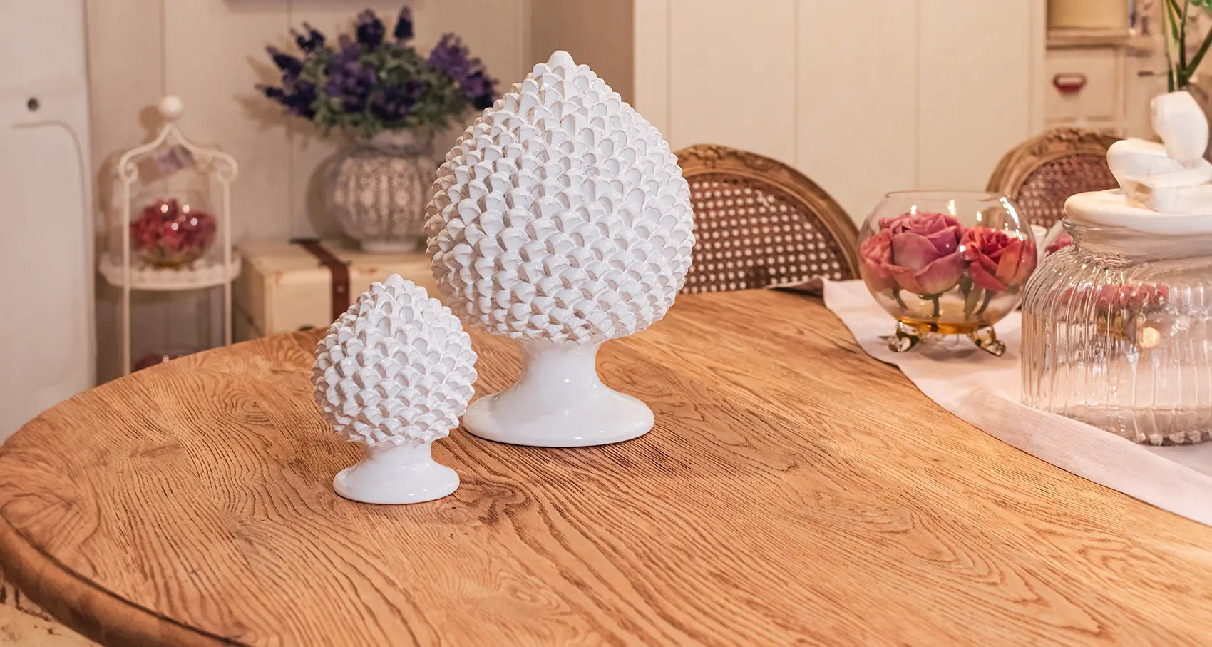 Due ceramiche di Caltagirone fatte a mano bianche su tavolo in legno con decorazioni floreali e arredo rustico