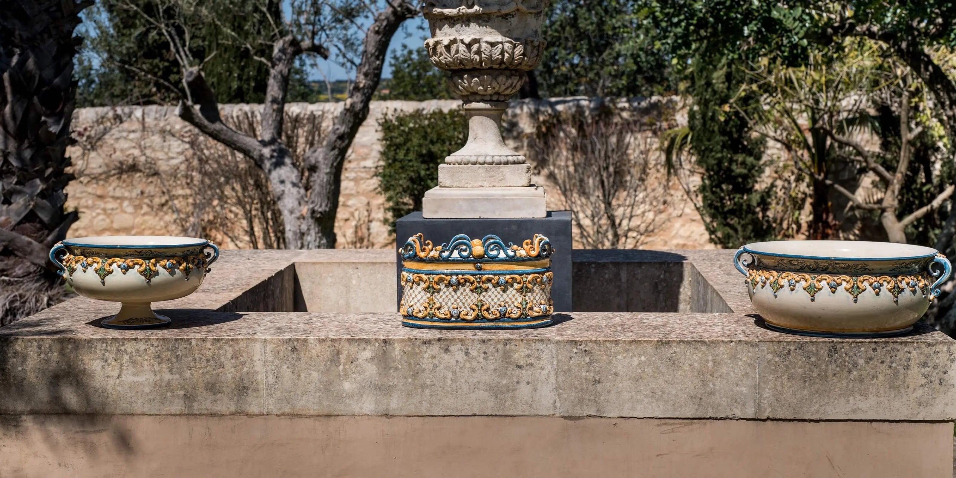 Portavasi ceramiche di Caltagirone fatti a mano con decorazioni blu e oro su pietra all'aperto