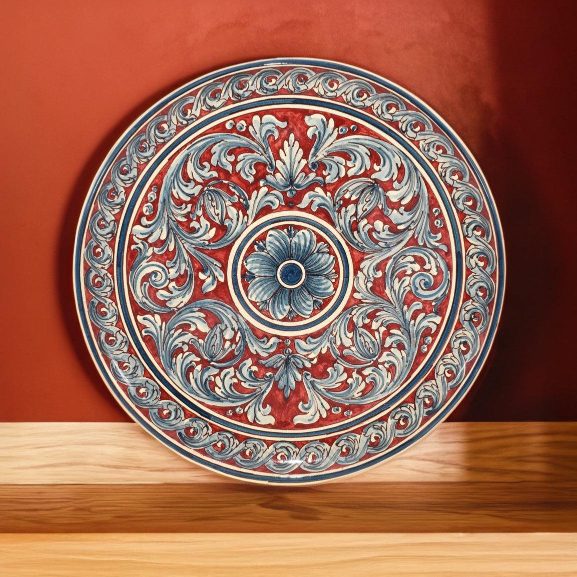 Piatto ornamentale in ceramica artigianale di Caltagirone con motivi floreali blu e bordeaux, fatti a mano