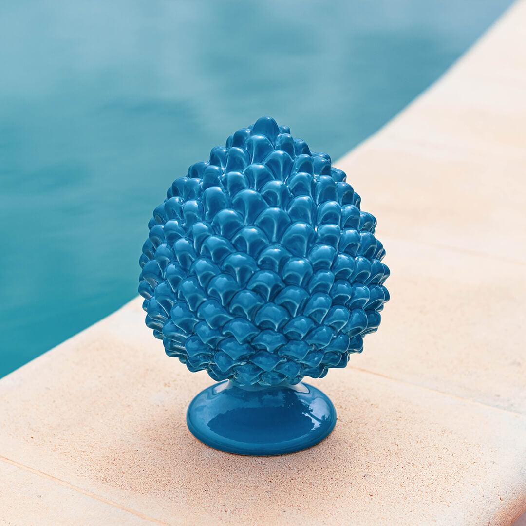 Pigna artigianale turchese in ceramica di Caltagirone, fatti a mano, su bordo piscina.