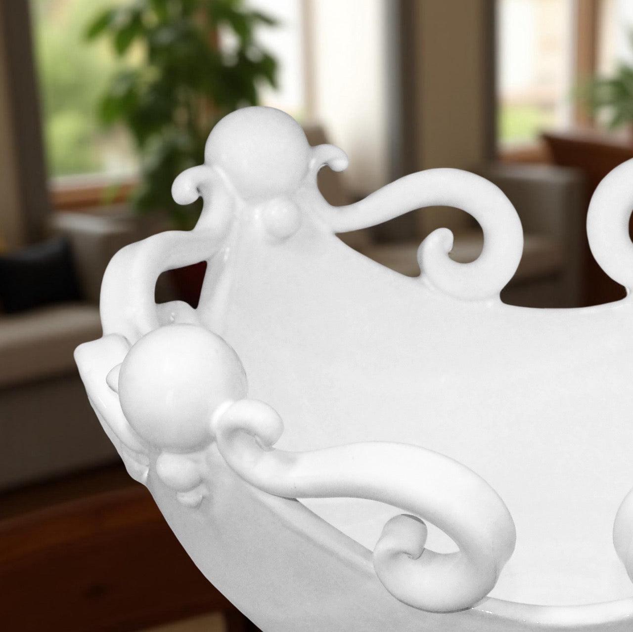 Ceramiche Caltagirone bianche fatte a mano con dettagli decorativi ricurvi in un ambiente interno